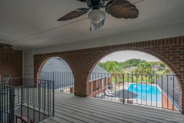 wooden deck with a fenced in pool and a ceiling fan