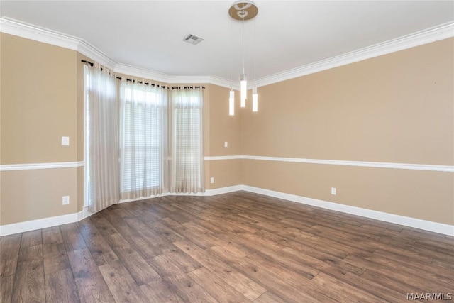 empty room featuring ornamental molding, visible vents, baseboards, and wood finished floors