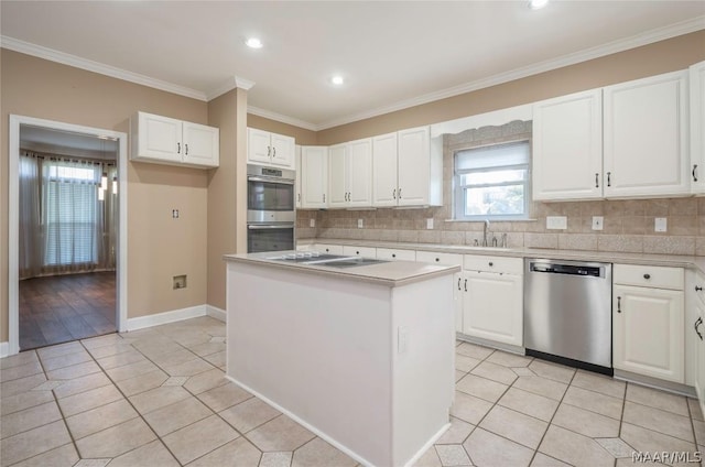 kitchen featuring light tile patterned flooring, stainless steel appliances, a kitchen island, white cabinetry, and ornamental molding