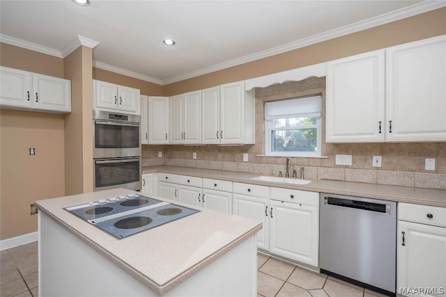 kitchen featuring a sink, white cabinets, appliances with stainless steel finishes, ornamental molding, and tasteful backsplash