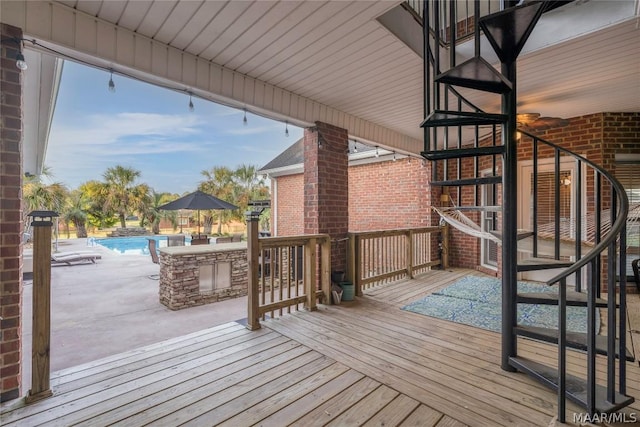 wooden deck featuring an outdoor pool and a patio