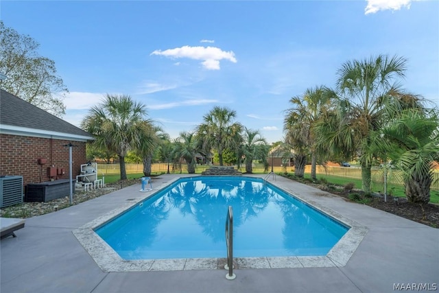 view of swimming pool featuring central AC unit, a patio area, fence, and a fenced in pool