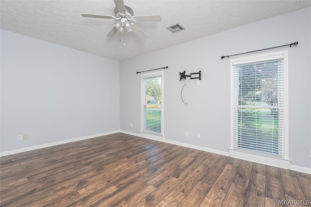 unfurnished room featuring visible vents, a textured ceiling, baseboards, and wood finished floors