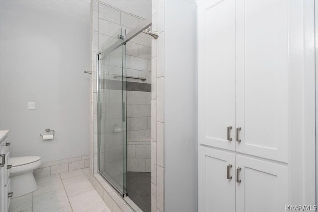 full bath with a stall shower, vanity, toilet, and baseboards