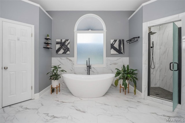 bathroom featuring marble finish floor, a marble finish shower, and a freestanding bath