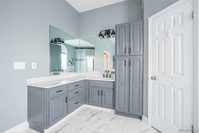 full bath featuring marble finish floor, a sink, and double vanity