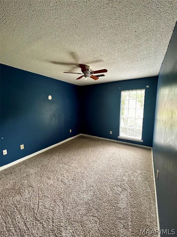 empty room featuring carpet, a textured ceiling, and ceiling fan