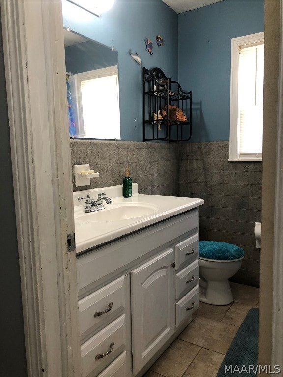 bathroom with vanity, tile patterned floors, tile walls, decorative backsplash, and toilet