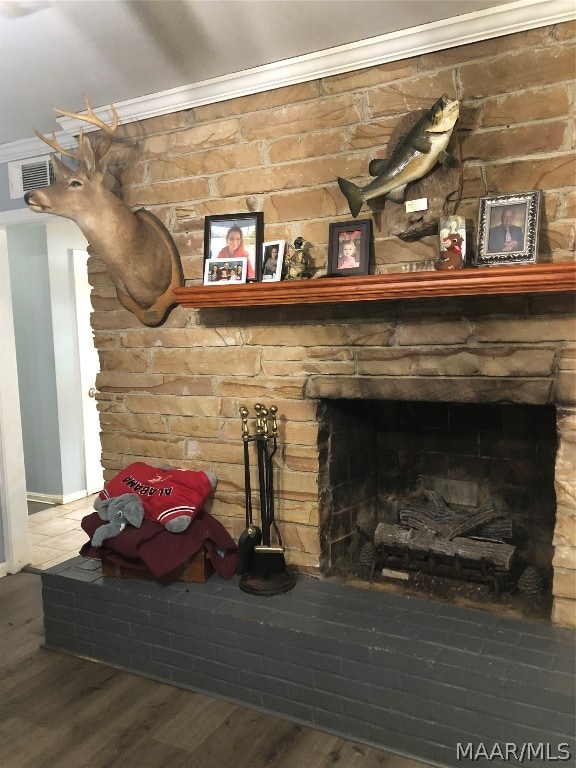 details featuring hardwood / wood-style flooring, a stone fireplace, and ornamental molding