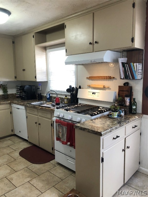 kitchen with sink, light tile patterned floors, and white appliances