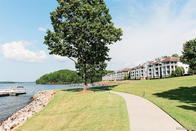 view of property's community with a lawn and a water view