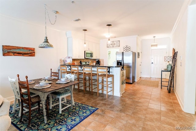 dining area with crown molding and light tile patterned floors