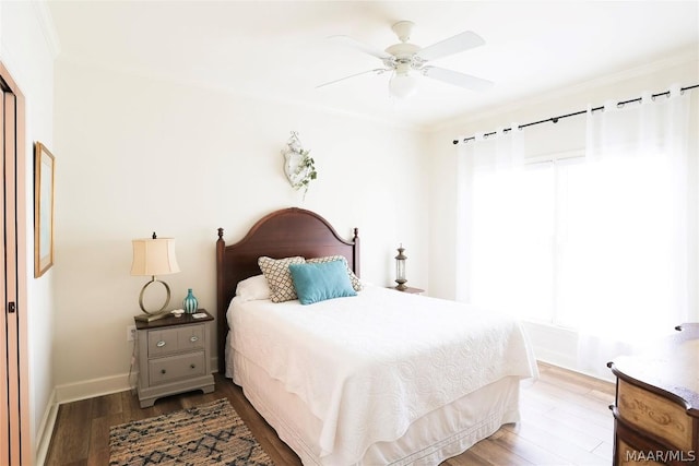 bedroom with multiple windows, dark hardwood / wood-style flooring, crown molding, and ceiling fan