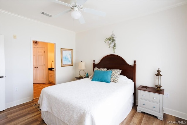 bedroom featuring hardwood / wood-style flooring, ensuite bath, ornamental molding, and ceiling fan