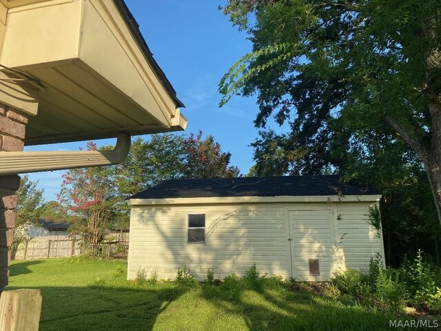 view of home's exterior with a yard and a storage unit