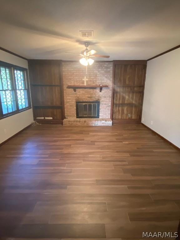 unfurnished living room featuring ceiling fan, a brick fireplace, ornamental molding, and hardwood / wood-style floors