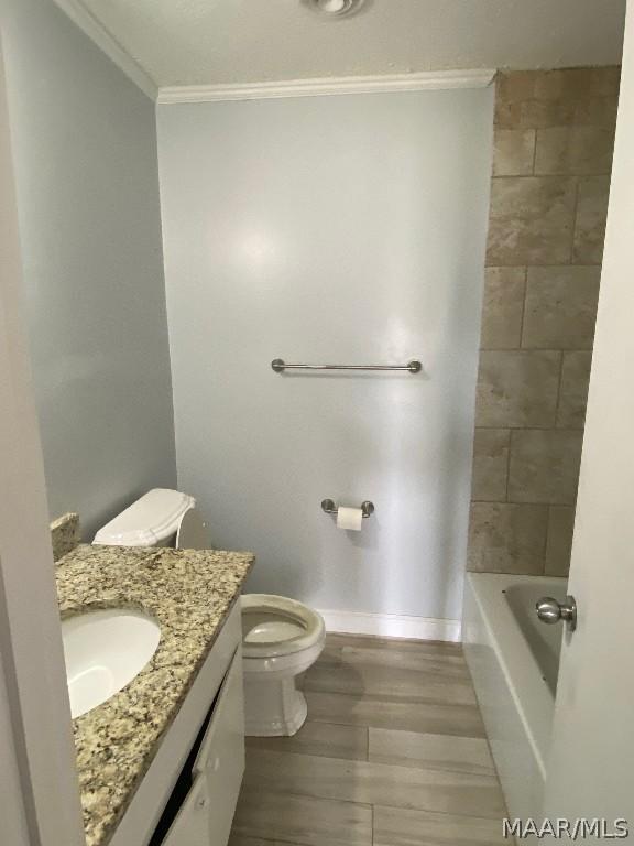 bathroom featuring toilet, crown molding, hardwood / wood-style flooring, and vanity