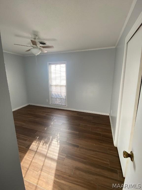 unfurnished room with ceiling fan, dark hardwood / wood-style floors, and ornamental molding