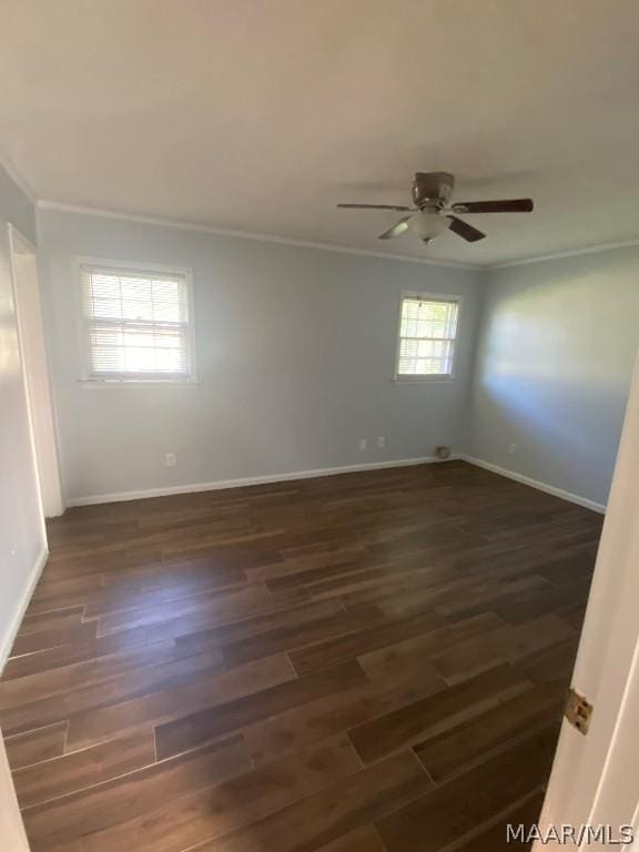 spare room featuring ceiling fan, dark wood-type flooring, and crown molding