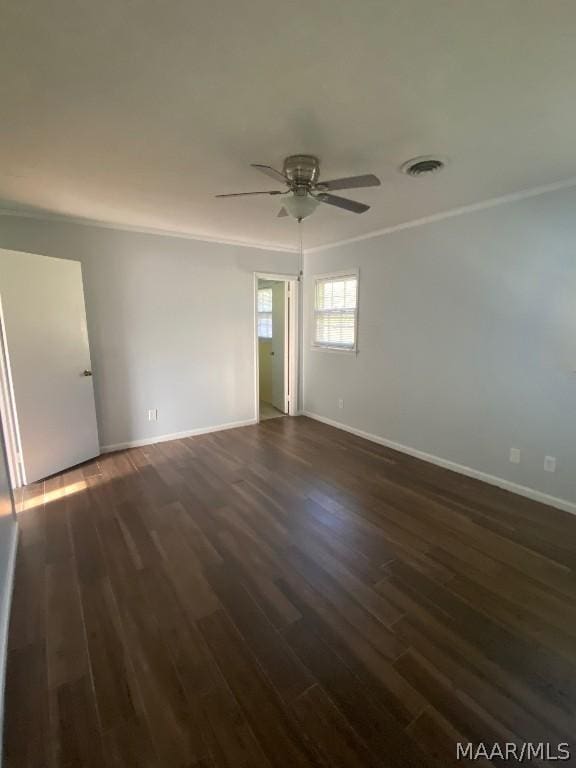 empty room featuring ceiling fan, dark wood-type flooring, and crown molding