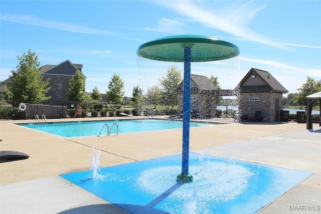 community pool with a patio area and fence