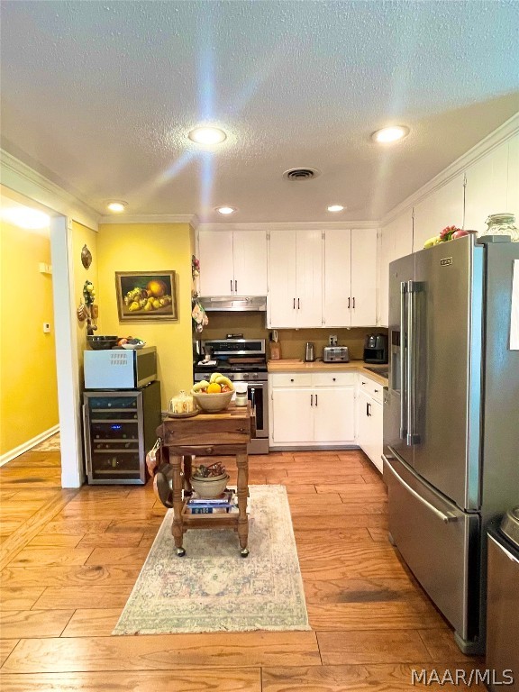 kitchen featuring white cabinetry, appliances with stainless steel finishes, and light hardwood / wood-style flooring