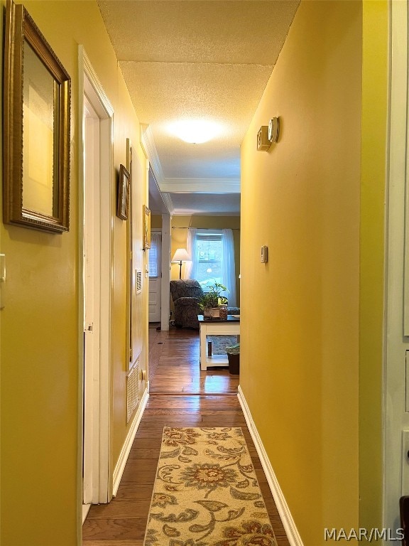 hallway featuring a textured ceiling and dark hardwood / wood-style flooring