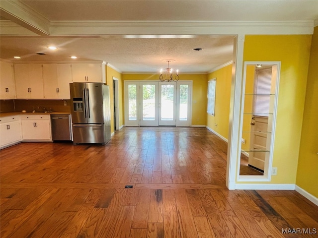 kitchen with crown molding, white cabinetry, stainless steel appliances, and hardwood / wood-style floors