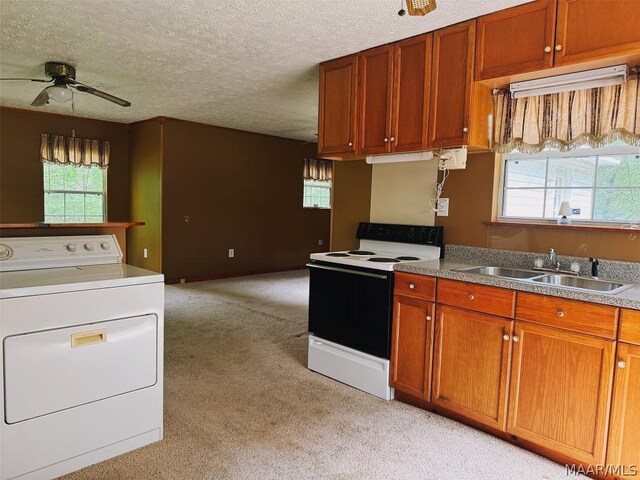 kitchen featuring a textured ceiling, washer / dryer, white range with electric cooktop, sink, and light colored carpet