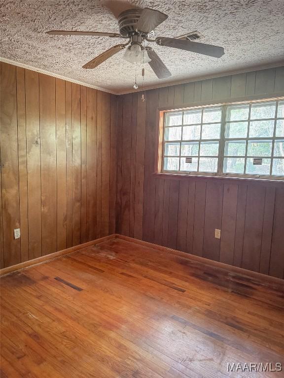 unfurnished room featuring wood walls and hardwood / wood-style flooring