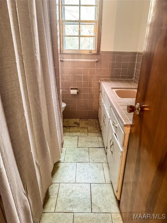 bathroom featuring tile walls and vanity