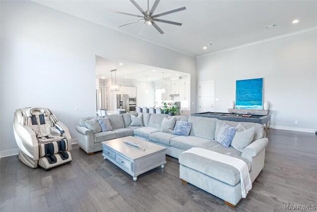 living room featuring ceiling fan, dark hardwood / wood-style floors, and crown molding