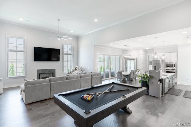 rec room featuring sink, a high end fireplace, light hardwood / wood-style flooring, and ornamental molding