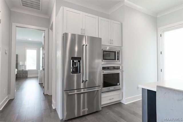 kitchen featuring white cabinetry, appliances with stainless steel finishes, crown molding, and dark hardwood / wood-style flooring