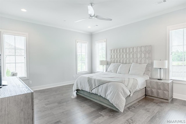 bedroom featuring crown molding, ceiling fan, wood-type flooring, and multiple windows