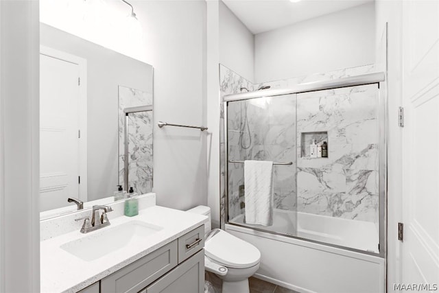 full bathroom with vanity, shower / bath combination with glass door, and toilet