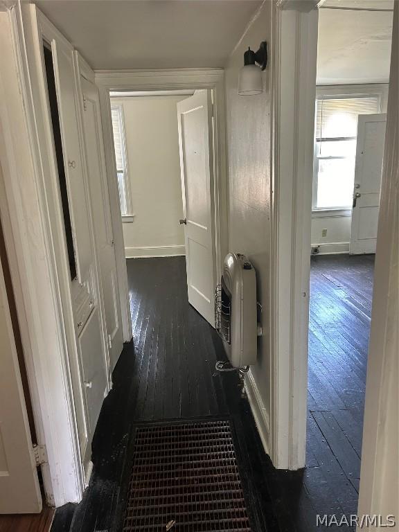 hall with baseboards, dark wood finished floors, and heating unit