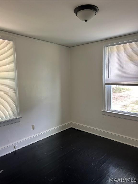 spare room with wood finished floors and baseboards