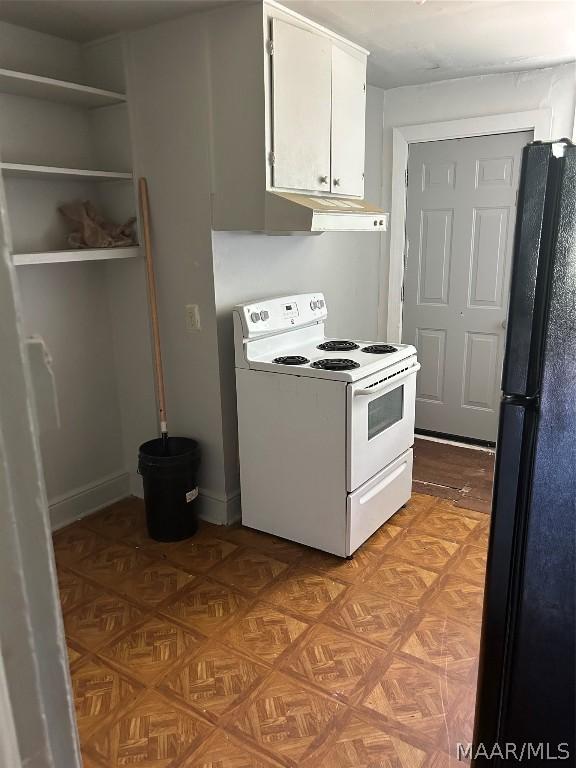 kitchen with electric stove, open shelves, freestanding refrigerator, and white cabinets