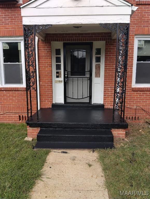 doorway to property with brick siding