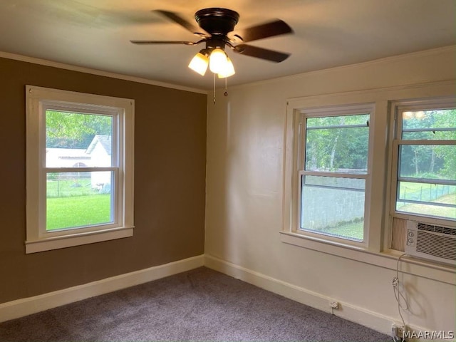 carpeted empty room featuring ceiling fan, cooling unit, a wealth of natural light, and ornamental molding