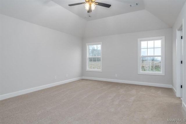 spare room with lofted ceiling, baseboards, visible vents, and light colored carpet