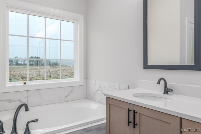 bathroom featuring a garden tub and vanity