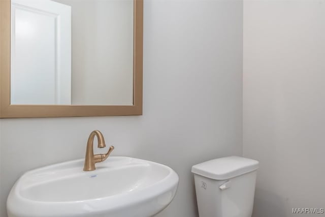 half bath featuring a sink and toilet