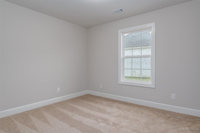 carpeted empty room featuring visible vents and baseboards