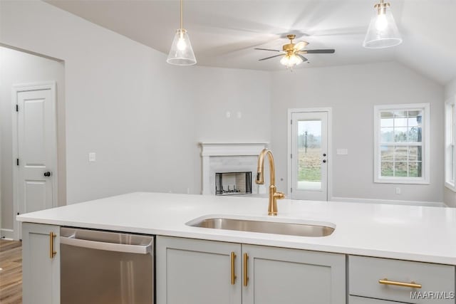 kitchen with pendant lighting, gray cabinets, light countertops, stainless steel dishwasher, and a sink