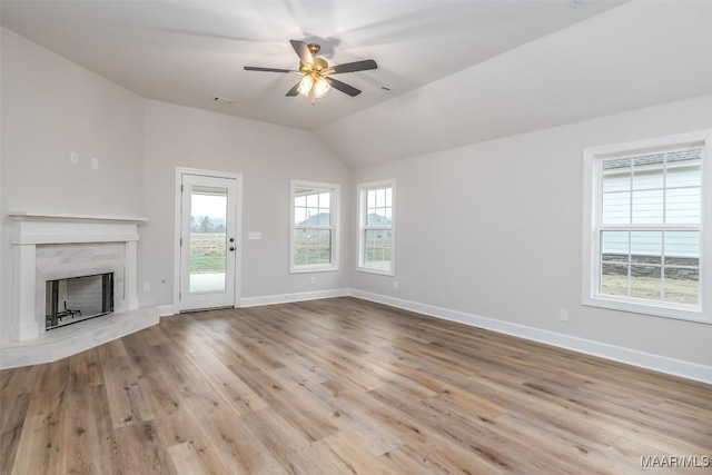 unfurnished living room featuring lofted ceiling, a fireplace, wood finished floors, a ceiling fan, and baseboards