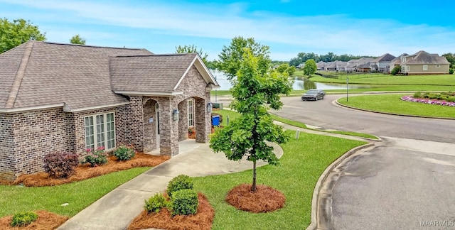 1426 Barret Park Way, Montgomery, AL 36117 - view of front of house with a front yard, roof with shingles, a water view, brick siding, and stone siding