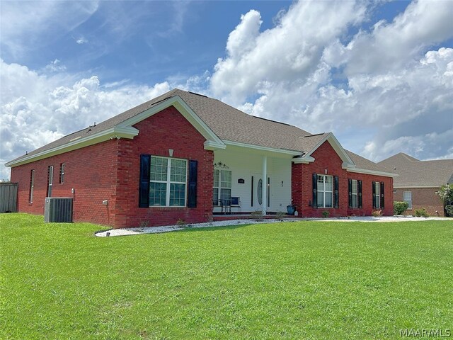 ranch-style home featuring central AC unit and a front yard