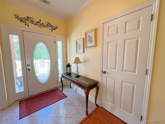 tiled entryway featuring crown molding